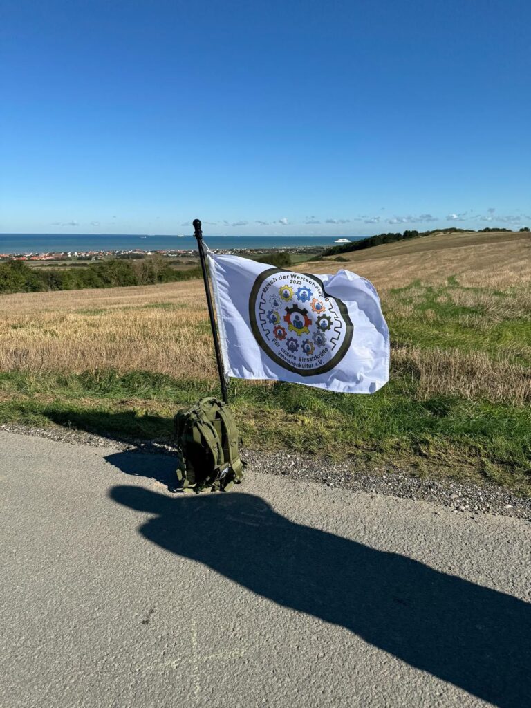 Ein Rucksack mit einer MdW-Flagge vor dem Hintergund des Ärmelkanals